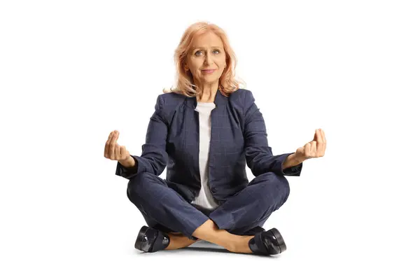 Geschäftsfrau Sitzt Mit Überkreuzten Beinen Auf Dem Boden Und Meditiert Stockfoto