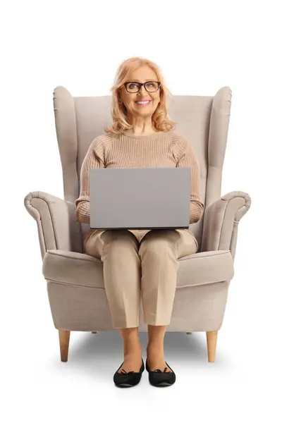 Glückliche Reife Frau Sitzt Einem Sessel Mit Einem Laptop Computer Stockbild