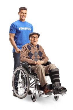 Beyaz arka planda, tekerlekli sandalyeli bir adama yardım eden gönüllü.