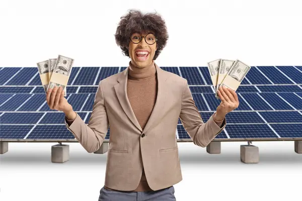 Joven Emocionado Sosteniendo Dinero Frente Paneles Solares Aislados Sobre Fondo —  Fotos de Stock