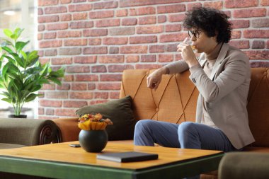 Bir kafede içki içen genç adam. 