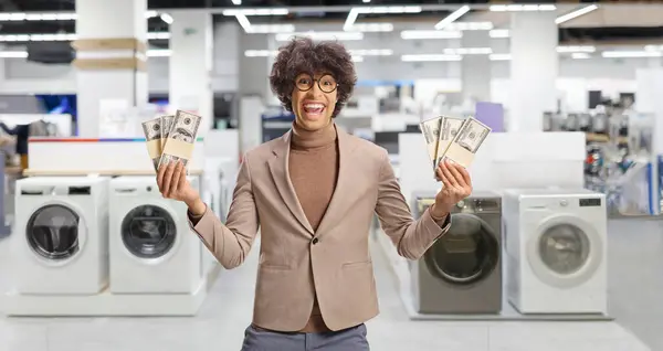 Young Excited Man Holding Stacks Money Store Washing Machines — Stock Photo, Image
