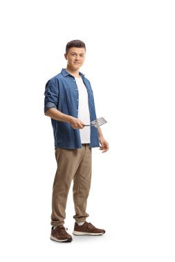 Elinde barbekü yapan genç bir adam beyaz arka planda izole edilmiş çatal bıçak yapıyor.