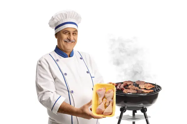 Chef Sosteniendo Paquete Carne Pollo Cruda Junto Una Parrilla Barbacoa — Foto de Stock