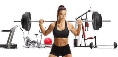 Ağırlık, spor ve spor malzemeleri taşıyan güçlü genç bir kadın, beyaz arka planda izole edilmiş.