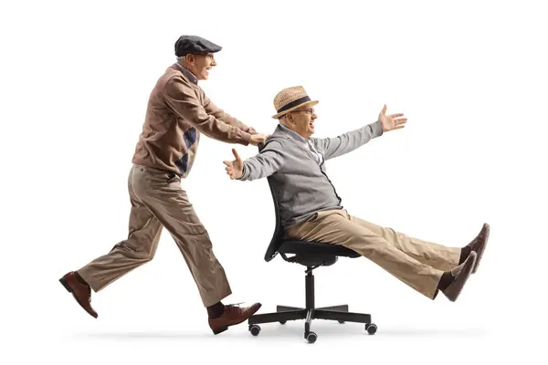 Oudere Man Duwen Een Vriend Een Bureaustoel Geïsoleerd Witte Achtergrond Stockfoto