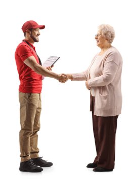 Full length profile shot of courier and an elderly woman shaking hands isolated on white background clipart