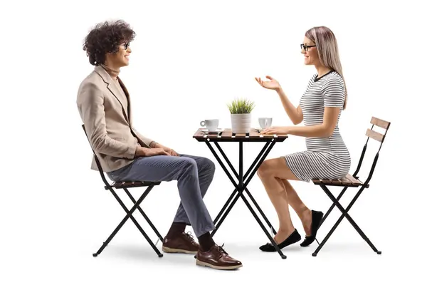 一个年轻女人坐在咖啡店里 与一个有着白人背景的年轻男人交谈 免版税图库照片