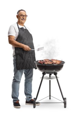 Olgun bir adam beyaz arka planda izole edilmiş barbekü yapıyor.