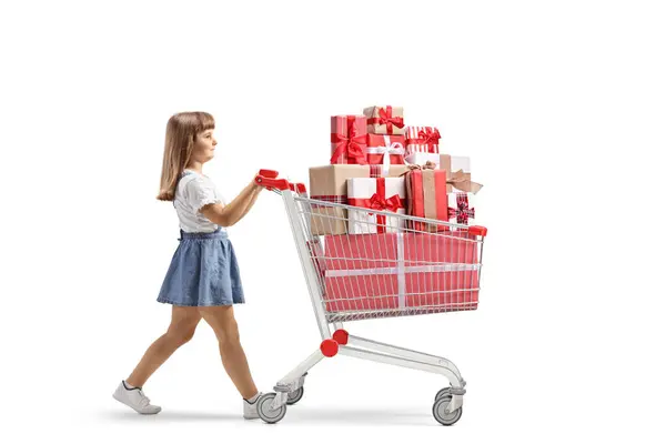 Little Girl Walking Pushing Shopping Cart Gift Boxes Isolated White lizenzfreie Stockbilder