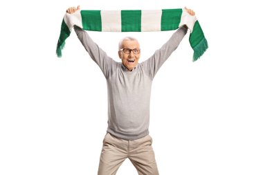 Mutlu yaşlı adam beyaz arka planda izole edilmiş yeşil ve beyaz bir eşarpla tezahürat yapıyor.