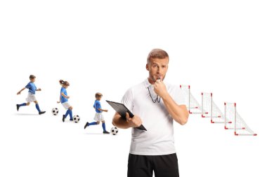 Antrenmanda ıslık çalan futbol koçu ve beyaz arka planda izole edilmiş futbol toplarıyla koşan çocuklar.