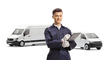 Beyaz arka planda izole edilmiş minibüslerin önündeki panoya yazı yazan üniformalı genç bir tamirci.