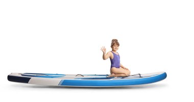 Küçük bir kızın SUP 'ye binip beyaz arka planda izole edilmiş bir şekilde el salladığı uzun bir profil fotoğrafı.