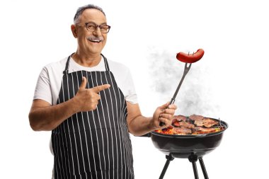 Beyaz arka planda izole edilmiş bir çatalda sosisli sandviçin önünde mutlu, olgun bir adam.