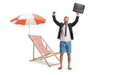 Plaj sandalyesi, şemsiye ve beyaz arka planda izole edilmiş bir evrak çantası tutan takım elbiseli ve mayo giymiş heyecanlı bir iş adamı.