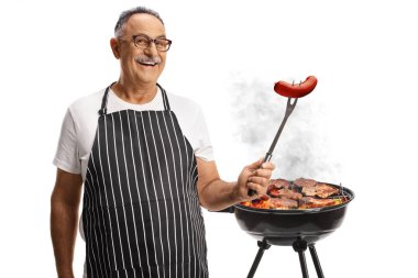 Beyaz arka planda izole edilmiş bir çatalda sosisli sandviçin önünde gülümseyen olgun bir adam.