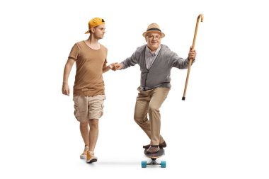 Genç adam beyaz arka planda, kaykaylı yaşlı bir adama yardım ediyor.