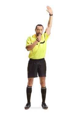 Kolları havada, beyaz arka planda ıslık çalan futbol hakemi.
