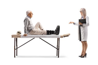 Kadın doktor, beyaz arka planda izole edilmiş ortopedik ayak desteği olan yaşlı bir adamla konuşuyor.