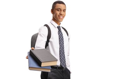 Afrikalı Amerikalı okul çocuğu kitap veriyor ve beyaz arka planda izole edilmiş kameraya bakıyor.