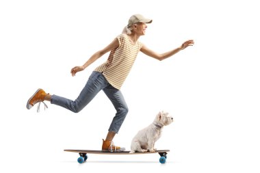 Beyaz arka planda izole edilmiş bir teriyer köpeğiyle uzun bir kaykaya binen bayan patenci.    