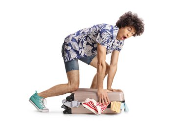 Aşırı bavullu komik genç adam beyaz arka planda izole edilmiş.