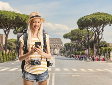 Roma, İtalya sokaklarında cep telefonu kullanan sırt çantalı mutlu bir kadın turist.