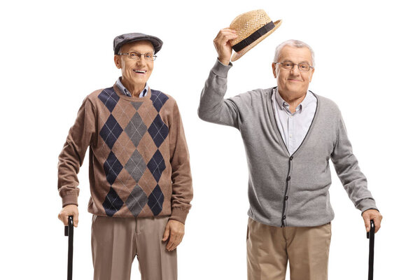 Senior men with walking canes, one greeting with his hat isolated on white background