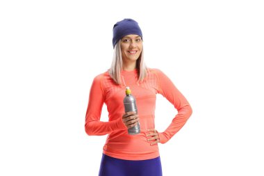 Koşu kıyafetleri içindeki genç bir kadın ve beyaz arka planda izole edilmiş bir şişe tutan bir şapka.