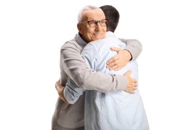 Yaşlı bir adam beyaz arka planda soyutlanmış genç bir adama sarılıyor.