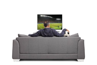 Televizyonda futbol seyreden ve beyaz arka planda izole bir şekilde kanepede oturan bir adamın arka plan görüntüsü.
