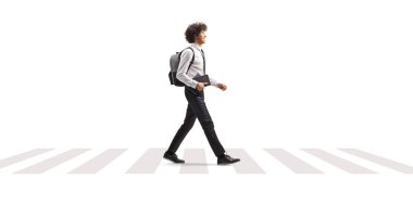 Üniversite öğrencisi beyaz arka planda kitap taşıyor ve sokağın karşısına geçiyor.