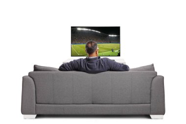 Yetişkin bir adamın televizyonun önünde oturup futbol izlediği ve beyaz arka planda izole bir kanepede oturduğu arka plan görüntüsü.