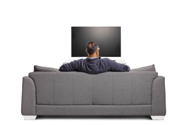 Rear view shot of a mature man in front of tv sitting on a sofa isolated on white background clipart