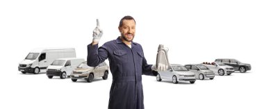 Araba tamircisi elinde bir motor yağı şişesi tutuyor ve beyaz arka planda izole edilmiş bir arabayı işaret ediyor.