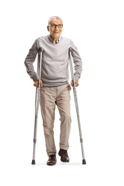 Beyaz arka planda koltuk değnekleriyle ayakta duran yaralı yaşlı bir adam.
