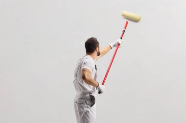 Ressam bir duvar boya silindiri ile boyama