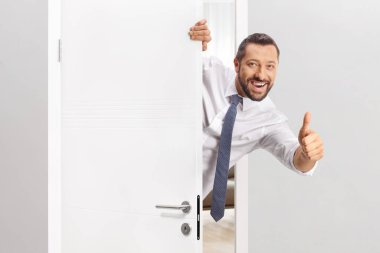 Neşeli bir adam kapıyı açıyor ve işaret ediyor.