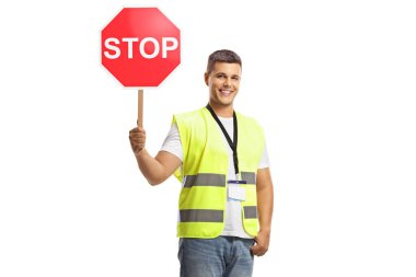 Güvenlik yelekli bir genç elinde beyaz arka planda izole edilmiş trafik levhası tutuyor.