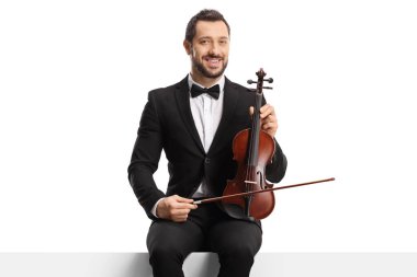 Papyonlu bir kemancı panelde oturuyor ve beyaz arka planda izole edilmiş bir keman tutuyor. 