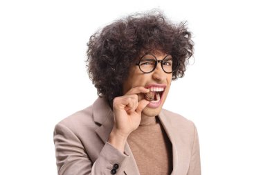 Dişleri beyaz arka planda izole edilmiş ceviz kırmaya çalışan genç bir adam.