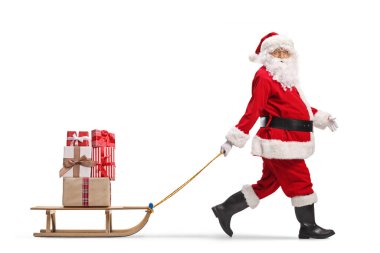 Santa Claus alking and pulling a wooden sled with presents isolated on white background    clipart