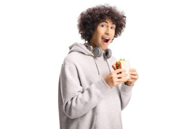 Kulaklıklı mutlu genç adam beyaz arka planda izole edilmiş peynirli sandviç yiyor.