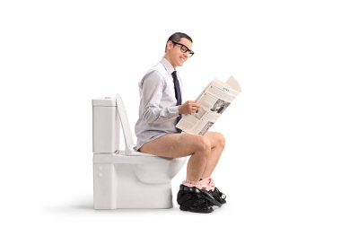 Adam gazete okuyor ve beyaz arka planda izole edilmiş bir tuvalette oturuyor.