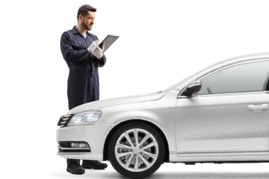 Araba tamircisi bir belge yazıyor ve beyaz arkaplanda izole edilmiş bir aracı kontrol ediyor