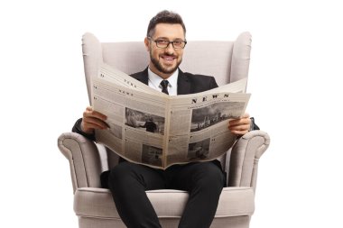Elinde gazete tutan ve beyaz arka planda izole bir şekilde gülümseyen yakışıklı bir adam.