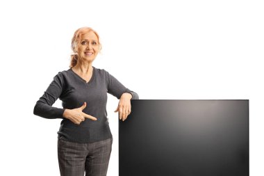 Beyaz arkaplanda izole edilmiş bir televizyon ekranını işaret eden kadın