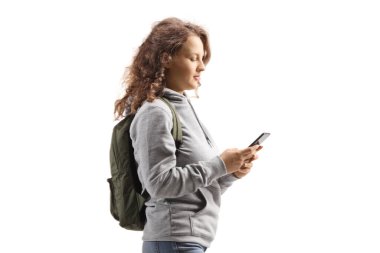 Beyaz arkaplanda izole edilmiş cep telefonunda yazan sırt çantalı bir öğrenci