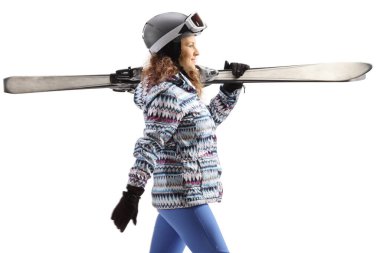 Beyaz arka planda, omzunda kayak ekipmanı taşıyan genç bir kadının profil fotoğrafı.